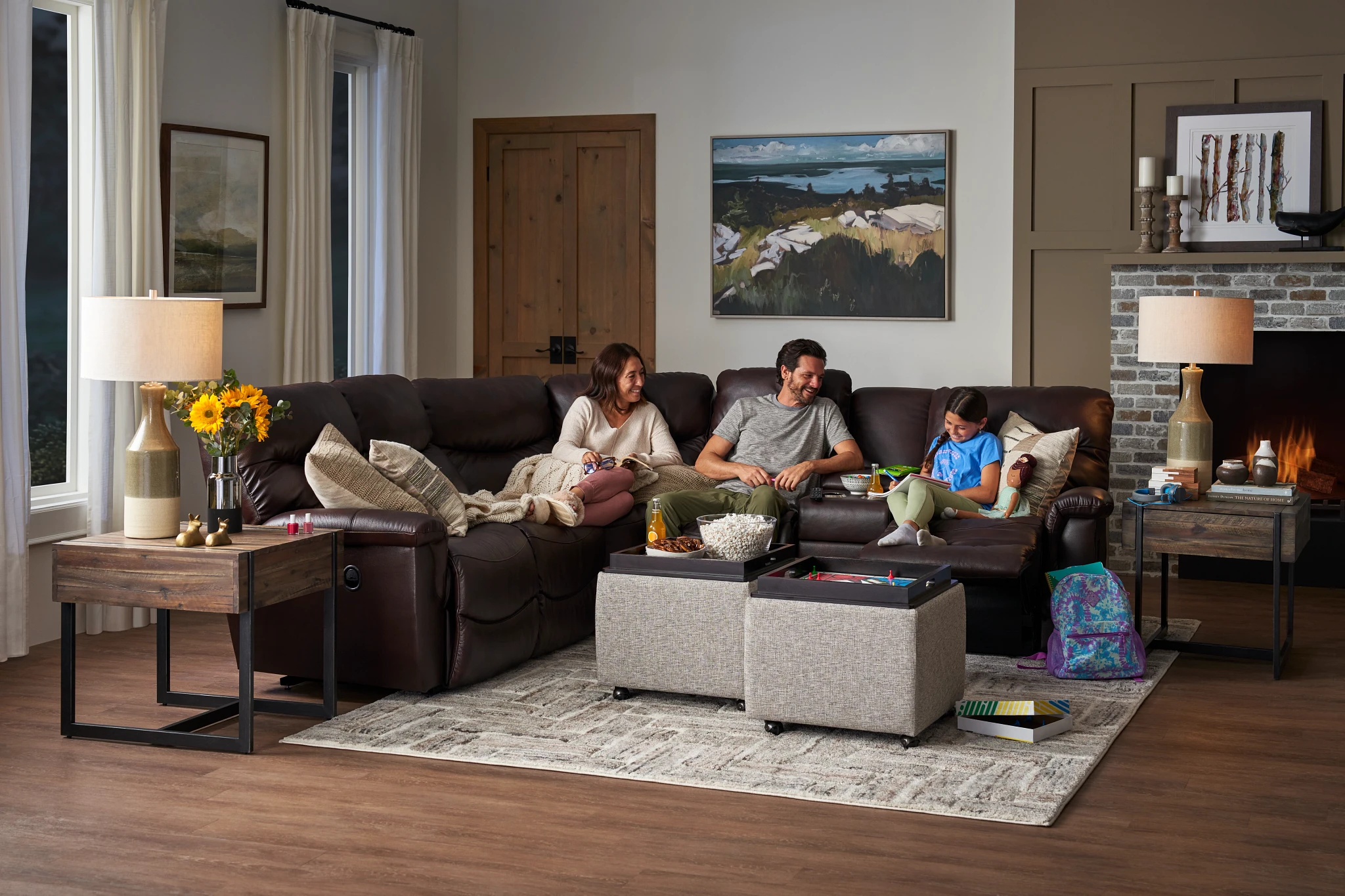 Family relaxing on a brown leather sectional in a living room.